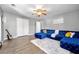 Bright living room with a stylish blue sectional couch, light gray walls and modern flooring at 3889 Elm Trace Dr, Loganville, GA 30052