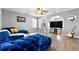 Spacious living room featuring a plush blue sectional sofa, wood floors, and a large TV at 3889 Elm Trace Dr, Loganville, GA 30052