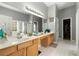 Bright bathroom with double vanity, large mirror, a soaking tub, and glass-enclosed shower at 3889 Elm Trace Dr, Loganville, GA 30052