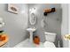 Well-lit powder room featuring a pedestal sink, oval mirror, and modern wall decor at 3889 Elm Trace Dr, Loganville, GA 30052