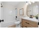 This bathroom features a wood vanity, white quartz countertop, tub/shower combo, and modern fixtures at 9347 Haley Ct, Jonesboro, GA 30238