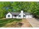 Charming one-story home with white siding, green shutters, two car garage and mature trees at 9347 Haley Ct, Jonesboro, GA 30238