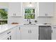 Bright kitchen featuring white cabinets, stainless steel appliances, and a view of trees through the window at 9347 Haley Ct, Jonesboro, GA 30238