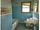 Dated bathroom with blue tile, old fixtures, and tub at 4758 Highway 81, Mcdonough, GA 30252