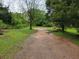 Long driveway leading to a home surrounded by lush greenery and mature trees at 4758 Highway 81, Mcdonough, GA 30252
