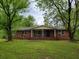Charming brick home featuring a covered front porch and a large, grassy yard at 4758 Highway 81, Mcdonough, GA 30252