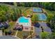 Aerial view of community pool, playground, and tennis courts surrounded by mature trees at 4766 Cedar Wood Sw Dr, Lilburn, GA 30047