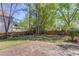 Open backyard featuring a stone patio with a wooden fence and mature trees at 4766 Cedar Wood Sw Dr, Lilburn, GA 30047