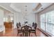 Elegant dining room with a tray ceiling, chandelier, and views into the kitchen at 4766 Cedar Wood Sw Dr, Lilburn, GA 30047