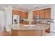 Well-lit kitchen showcasing the island with sink, granite countertops, and wooden cabinetry at 4766 Cedar Wood Sw Dr, Lilburn, GA 30047