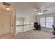 Upstairs landing with neutral carpet, white railing overlooking the entry, and an office area at 4766 Cedar Wood Sw Dr, Lilburn, GA 30047