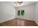 Bright bedroom featuring hardwood floors, a ceiling fan, and a window view of lush greenery at 492 Mary Hill Ln, Douglasville, GA 30134