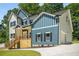 Side view of a two-story home showcasing blue and gray exterior, a wooden deck, and a convenient attached garage at 492 Mary Hill Ln, Douglasville, GA 30134