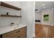 Stylish butler's pantry adjacent to a living room with decorative fireplace and floating shelves at 492 Mary Hill Ln, Douglasville, GA 30134