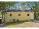 View of the back of the house featuring a bright yellow exterior and grassy yard at 6149 Josephine Rd, Atlanta, GA 30340
