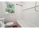 Clean bathroom featuring white subway tiles, a tub, and a window at 6149 Josephine Rd, Atlanta, GA 30340