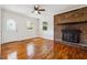Well-lit living room with hardwood floors, a brick fireplace, and a decorative front door at 6149 Josephine Rd, Atlanta, GA 30340