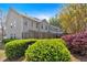 Townhome backyard with a wood fence, green bushes, and red and yellow flowering trees at 706 Woodland Pl, Woodstock, GA 30188