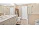Bright bathroom featuring double sinks, light wood floors, a toilet, and a glass shower at 706 Woodland Pl, Woodstock, GA 30188