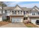 Charming townhome featuring a two-car garage and well-manicured landscaping at 706 Woodland Pl, Woodstock, GA 30188