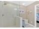 Walk-in shower featuring white textured tiling and a light gray stone floor at 706 Woodland Pl, Woodstock, GA 30188