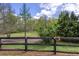 Picture of a beautiful backyard with a wired-fence, mature trees, and green grass at 1546 Silvaner Nw Ave # 20, Kennesaw, GA 30152