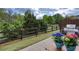 Backyard view showcases flower pots on a wood table, a grill, a fenced in yard, and mature trees at 1546 Silvaner Nw Ave # 20, Kennesaw, GA 30152