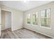 Cozy bedroom featuring three large windows, wood-style flooring, neutral paint, and ample natural light at 300 Radner Run, Lawrenceville, GA 30043