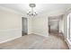 An empty dining room with crown molding, chandelier, natural lighting, and wood-style flooring at 300 Radner Run, Lawrenceville, GA 30043