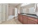 Bathroom featuring granite countertop, wood cabinet, and tiled floors and shower at 3311 Keenland Rd, Marietta, GA 30062
