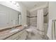 Well-lit bathroom featuring a marble countertop vanity and tiled shower-tub combination at 3311 Keenland Rd, Marietta, GA 30062