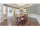 Dining room with an elegant chandelier over a long dining table, wainscoting, and open access to other rooms at 3311 Keenland Rd, Marietta, GA 30062