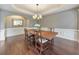 Formal dining room features hardwood floors, wainscoting, and a stylish chandelier over the wood dining table at 3311 Keenland Rd, Marietta, GA 30062