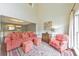 Bright living room featuring high ceilings, large windows, and a cozy seating arrangement with a pink sofa and arm chair at 3311 Keenland Rd, Marietta, GA 30062