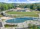 Panoramic aerial view of a vibrant park with a unique walking bridge, ponds, and inviting recreational areas at 3932 Boston Common St, Suwanee, GA 30024