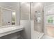 Modern bathroom featuring vanity with lighted mirror, and glass shower with tiled accent wall and door at 3932 Boston Common St, Suwanee, GA 30024