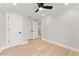 Bedroom featuring hardwood floors, a ceiling fan, and three white doors at 3932 Boston Common St, Suwanee, GA 30024