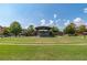 Community park with large lawn, trees, and covered stage area under blue skies at 3932 Boston Common St, Suwanee, GA 30024