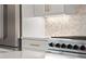 Modern kitchen with stainless steel refrigerator, white cabinets, and designer backsplash at 3932 Boston Common St, Suwanee, GA 30024