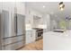 Modern kitchen featuring stainless steel appliances, white cabinetry, quartz counters and wood floors at 3932 Boston Common St, Suwanee, GA 30024