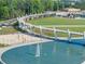 Modern park featuring a unique walking bridge over a pond, with a sand volleyball court and green space at 3932 Boston Common St, Suwanee, GA 30024