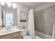 Hall bath features a vanity with tile surround and a shower with white shower curtain at 412 Nickajack Retreat Ln, Smyrna, GA 30082
