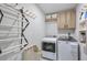 Laundry room includes a washer and dryer, storage cabinets, hanging rack, and built-in storage at 412 Nickajack Retreat Ln, Smyrna, GA 30082