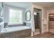 Spacious main bath features a soaking tub under a window next to walk-in shower and closet at 412 Nickajack Retreat Ln, Smyrna, GA 30082