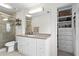 Well-lit bathroom with a glass-enclosed shower, white vanity, and functional built-in closet shelves at 1 James River Ne Pl, Atlanta, GA 30342