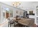 An open dining space with a rustic table, elegant chandelier and an open doorway to the patio at 1 James River Ne Pl, Atlanta, GA 30342