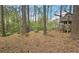 View of a spacious, wooded backyard with a charming wooden treehouse at 1200 Izod Ct, Lawrenceville, GA 30044