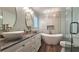 Bathroom featuring double sinks with stone countertops, modern fixtures, and a separate tub and shower at 1200 Izod Ct, Lawrenceville, GA 30044
