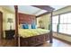 Bright bedroom boasts a four-poster bed, hardwood floors and large windows that let in natural light at 1200 Izod Ct, Lawrenceville, GA 30044