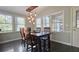 Bright breakfast nook featuring a rustic wood table, modern lighting, and multiple windows at 1200 Izod Ct, Lawrenceville, GA 30044